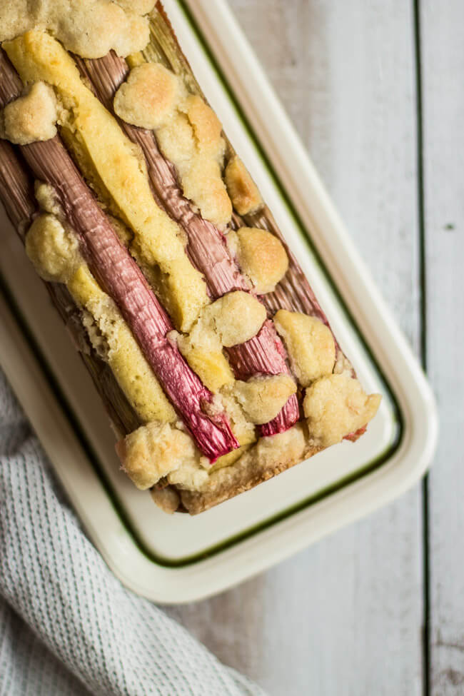 Buttermilch Kuchen mit Rhabarber und STreuseln auf weißer Porzellan platte