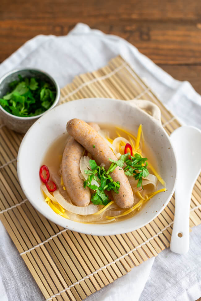 Saure Zipfel Thai Style mit reichlich Zwiebeln und Karotten im Essigsud mit Kaffirlimettenblättern und Zitronengras. Zu den Bratwürsten im Essigsud gibt es Koriander und rote Chili.