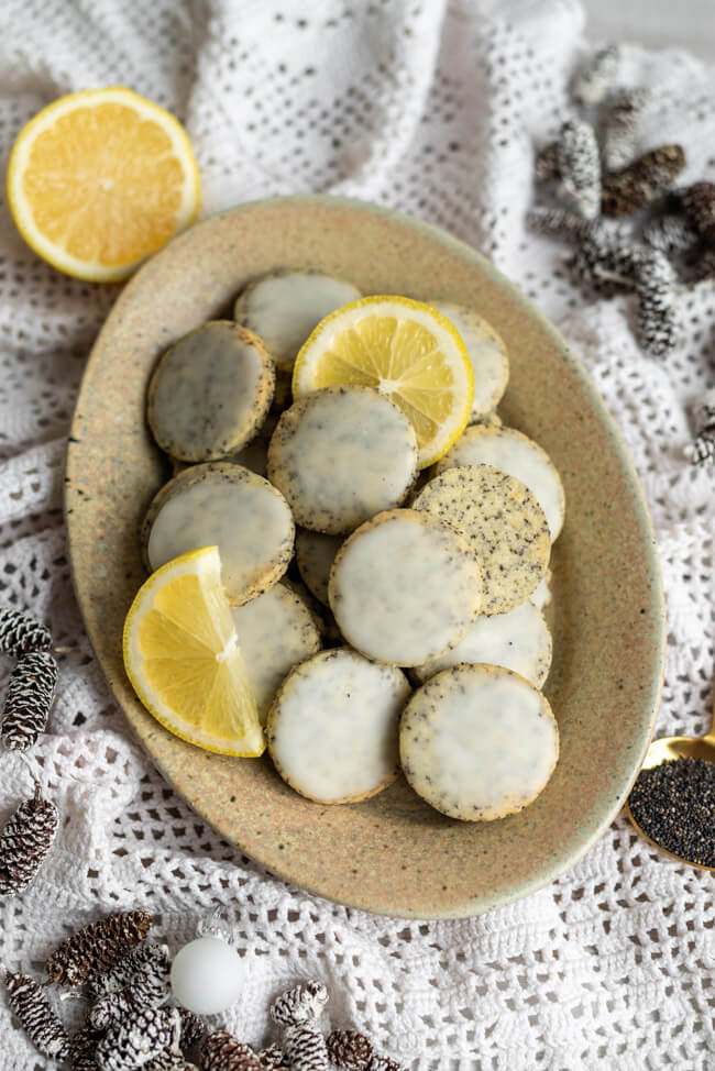 Zitrone-Mohn-Taler - köstliche Weihnachtsplätzchen mit Frischekick auf hellem Porzellanteller.