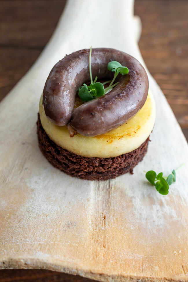 Originalrezept aus Kitchen Impossible: Lebkuchenwurst auf Lebkuchen mit Apfelring serviert auf Schaufelknochen.
