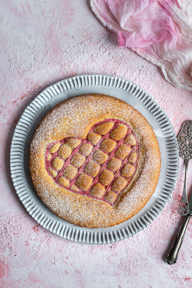 Steppdeckenkuchen für den 14.02.: Herzkuchen zum Valentinstag mit Erdbeerquark auf rosa Untergrund..