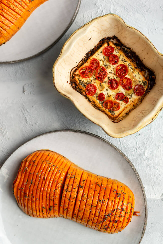 Hasselback Butternuss Kürbis mit mariniertem Feta, mit Tomaten, Knoblauch und Olivenöl, aus dem Ofen.