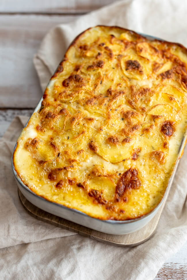 Kartoffelgratin deluxe mit Langres AOP in weißer Auflaufform, frisch aus dem Ofen.