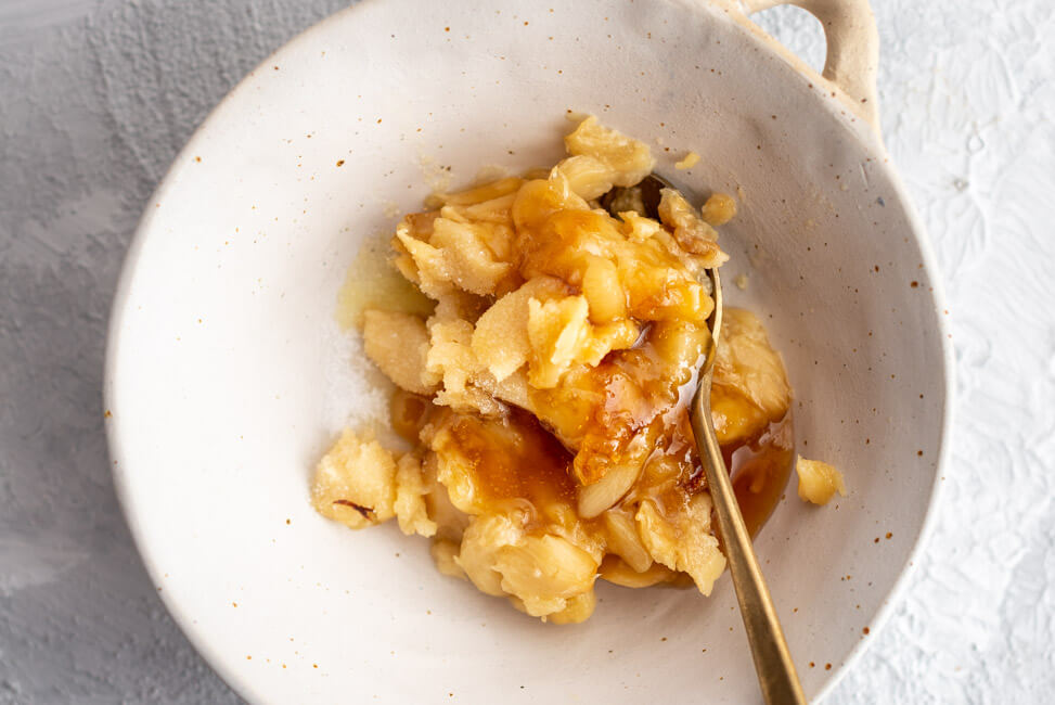 Knoblauchsauce aus geröstetem Knoblauch mit Olivenöl und Honig in weißer Keramikschale.