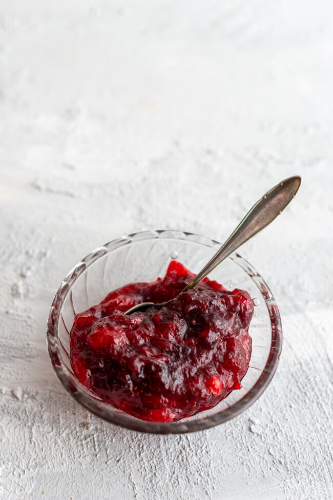 Cranberry Kompott mit Grand Manier in Glasschale auf hellem Untergrund.