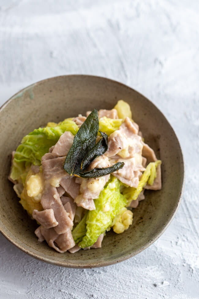Pizzoccheri Valtellinesi - Pasta aus Buchweizenmehl mit Wirsing, Kartoffeln, Salbei, Knoblauch, brauner Butter und Käse - aus Kitchen Impossible in grauem Keramikteller auf hellem Untergrund.