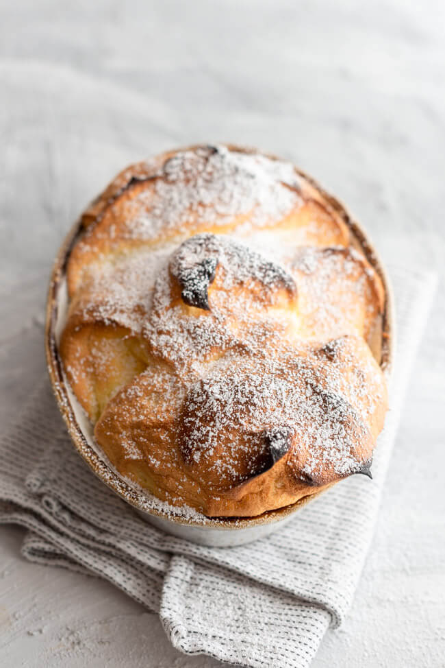 Salzburger Nockerl mit Puderzucker bestäubt aus Kitchen Impossible in Auflaufform auf hellem Untergrund.