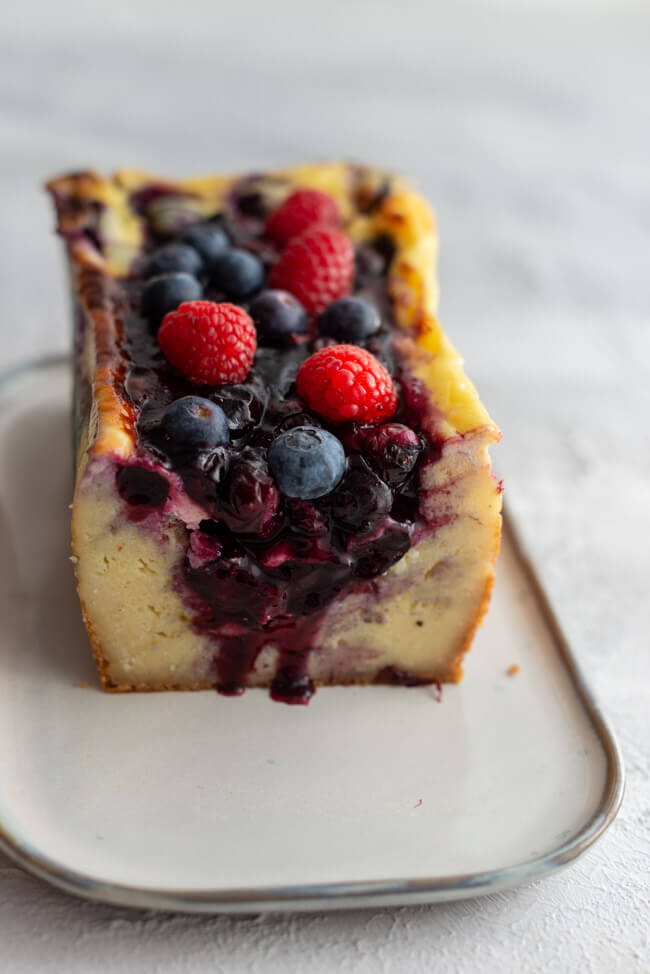 Ukrainischer Beeren-Grießkuchen angeschnitten auf hellem Untergrund.