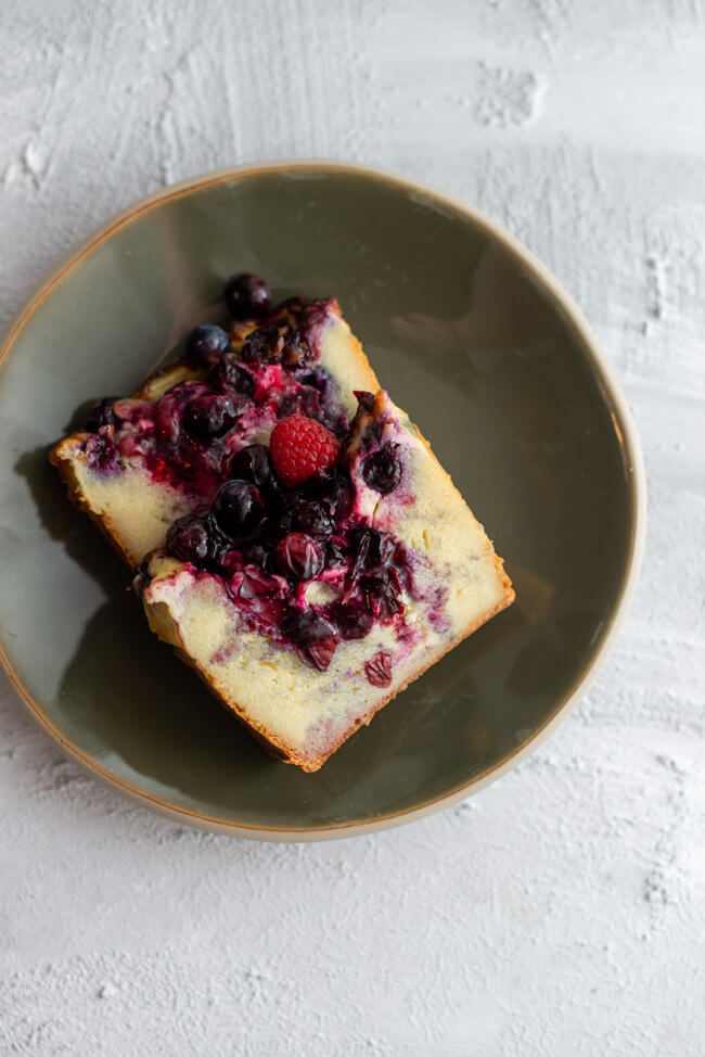Zwei Stück ukrainischer Beeren-Grießkuchen angeschnitten auf grünem Teller.