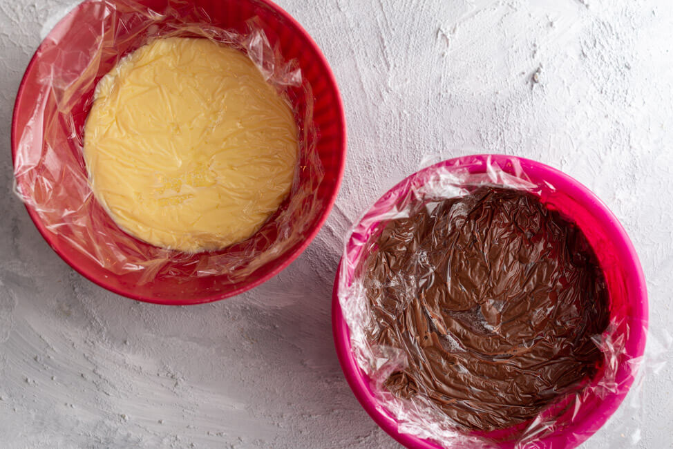 Creme Inglese, hell und dunkel, in Schüssel mit Frischhalteflie abgedeckt.