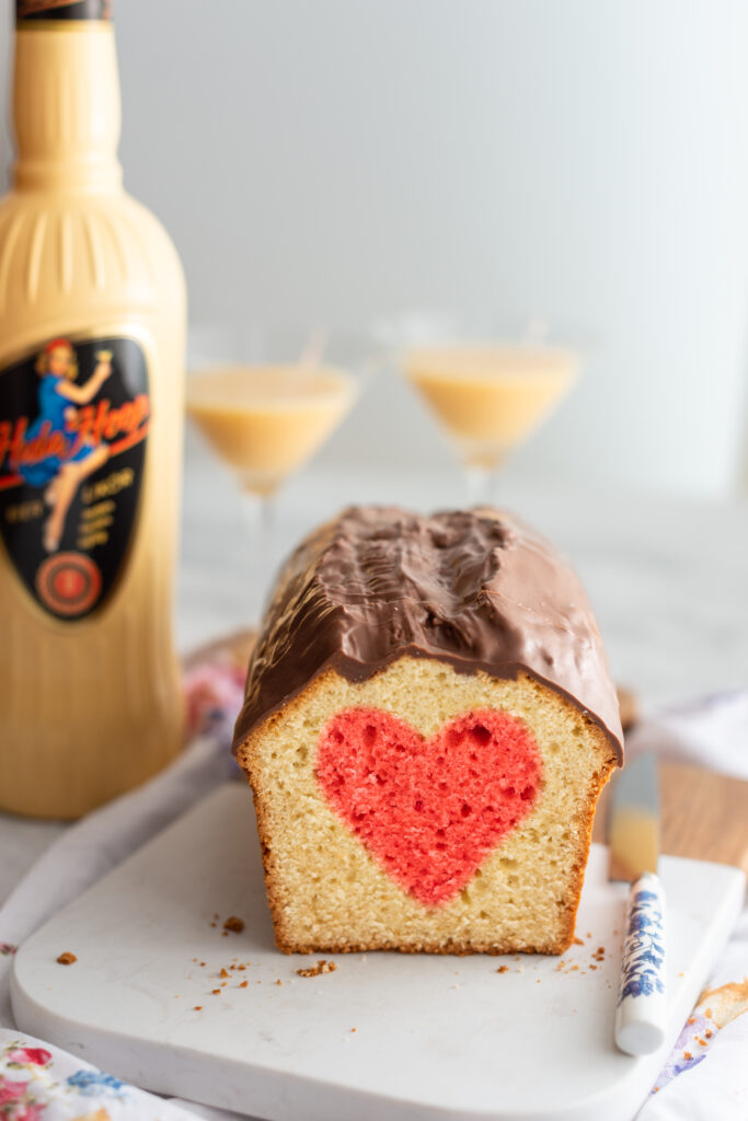 Herzkuchen mit Eierlikör und Schokoladenglasur, aufgeschnitten auf Marmorbrett.