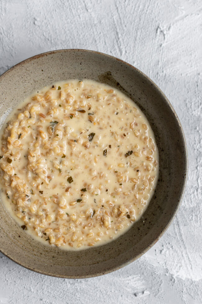 Originalrezept aus Kitchen Impossible: Orzotto in grauem Keramikteller.