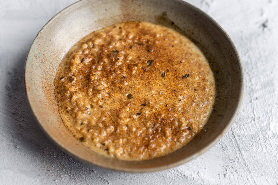 Originalrezept aus Kitchen Impossible: Orzotto mit Zichorienkaffee in grauem Keramikteller.