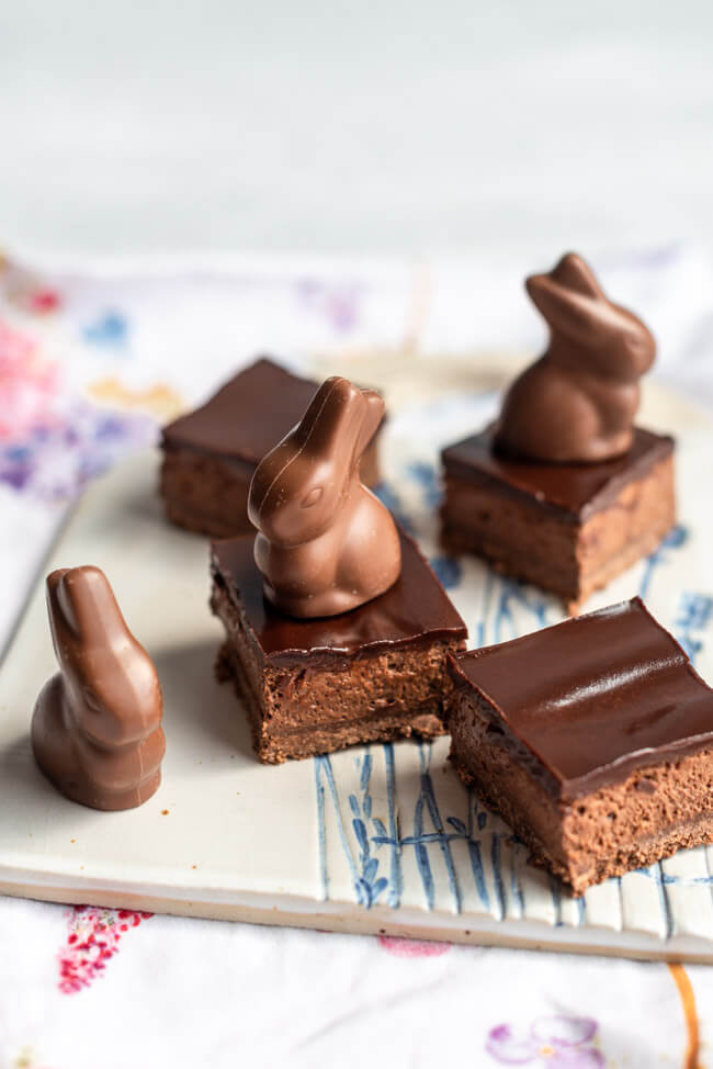 Schokoladen-Mousse-Törtchen mit Schokoladenhasen auf weißer Keramikplatte.