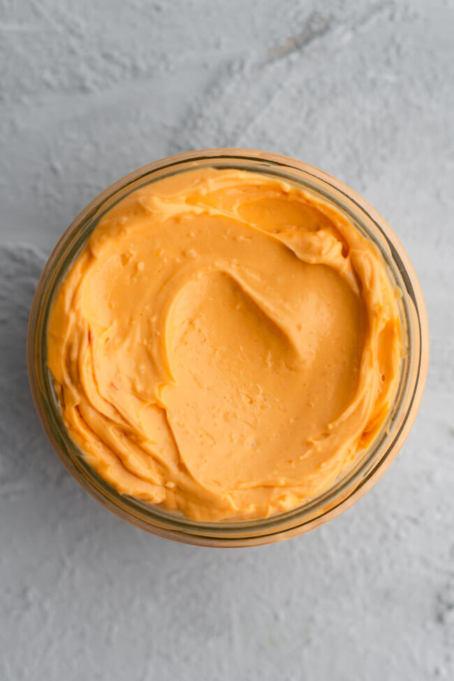 Ein Glas von Mamas Knoblauchbutter auf hellem Untergrund.