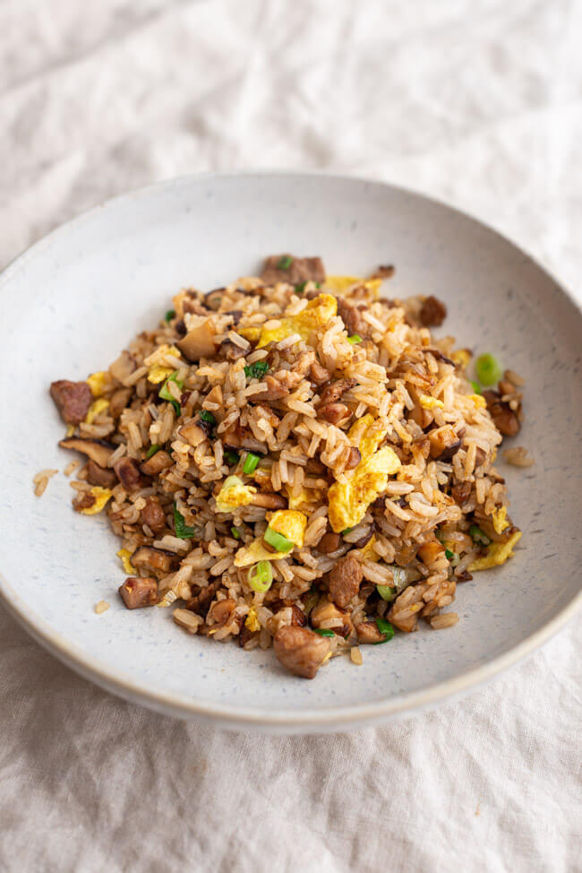 Eine Portion Fried Rice aus Kitchen Impossible auf weißem Keramikteller und hellem Untergrund.