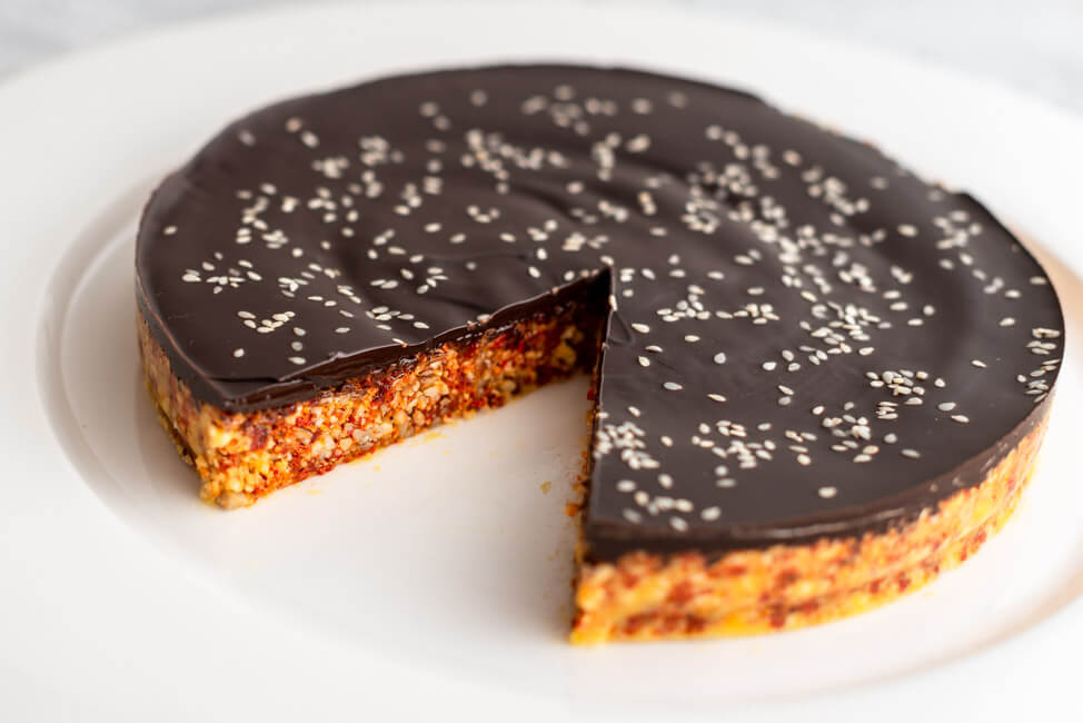 Power Cake, glasiert mit dunkler Schokolade auf weißem Teller und hellem Untergrund.