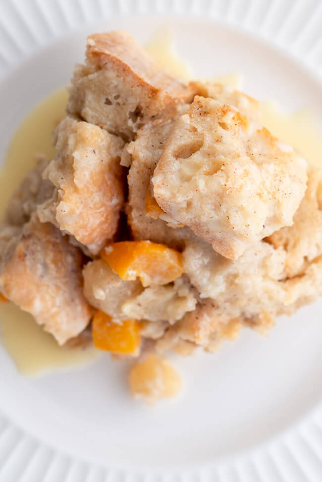Bread Pudding mit Rumsoße auf weißem Teller.