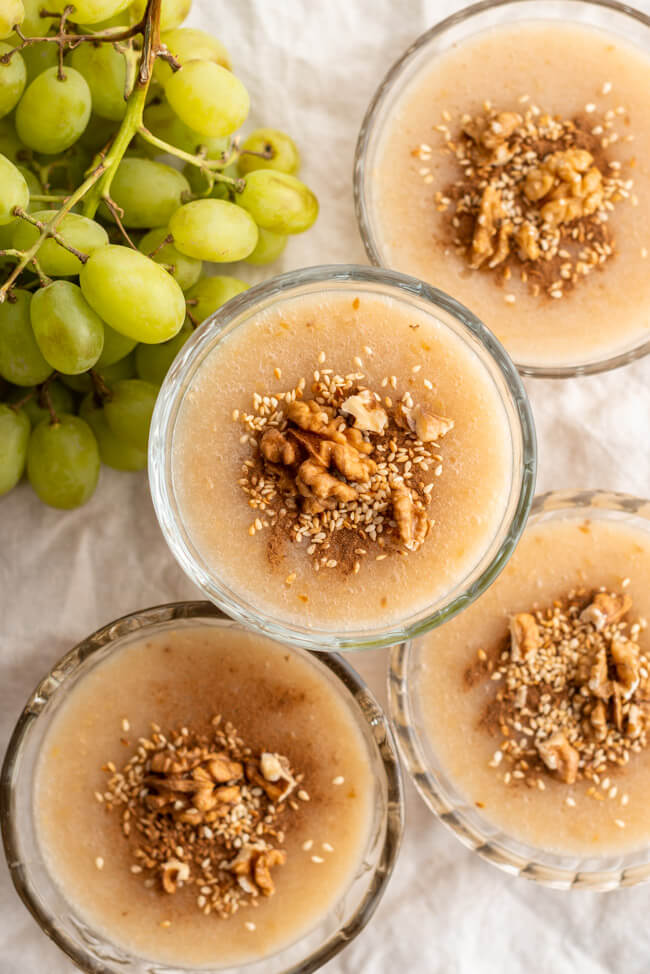 Glasschälchen mit kretischem Traubenpudding Moustalevria auf hellem Untergrund.