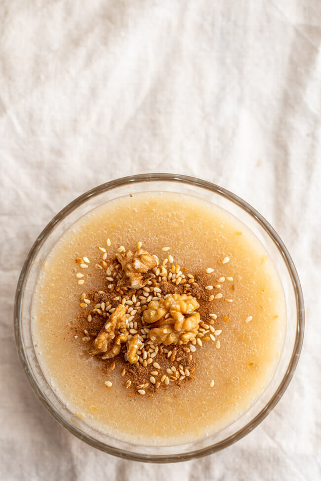 Glasschälchen mit kretischem Traubenpudding Moustalevria auf hellem Untergrund.
