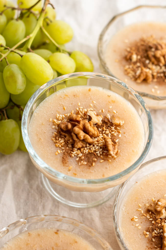 Glasschälchen mit kretischem Traubenpudding Moustalevria auf hellem Untergrund.