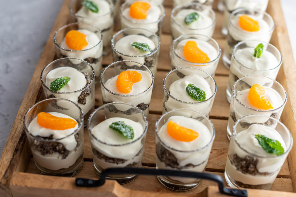 Dessert in Gläschen auf Holztablett.