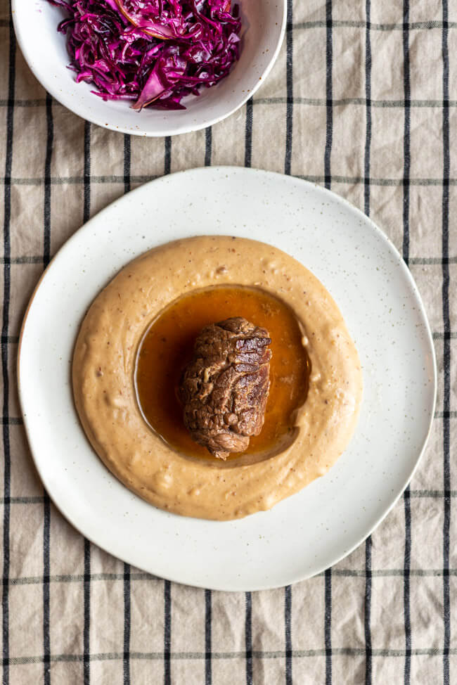 Originalrezept aus Vronis Lieblingsschmankerl: Roulade mit Maronenpüree und Rotkohlsalat auf hellem Porzellanteller von Foodbloggerin Tina.