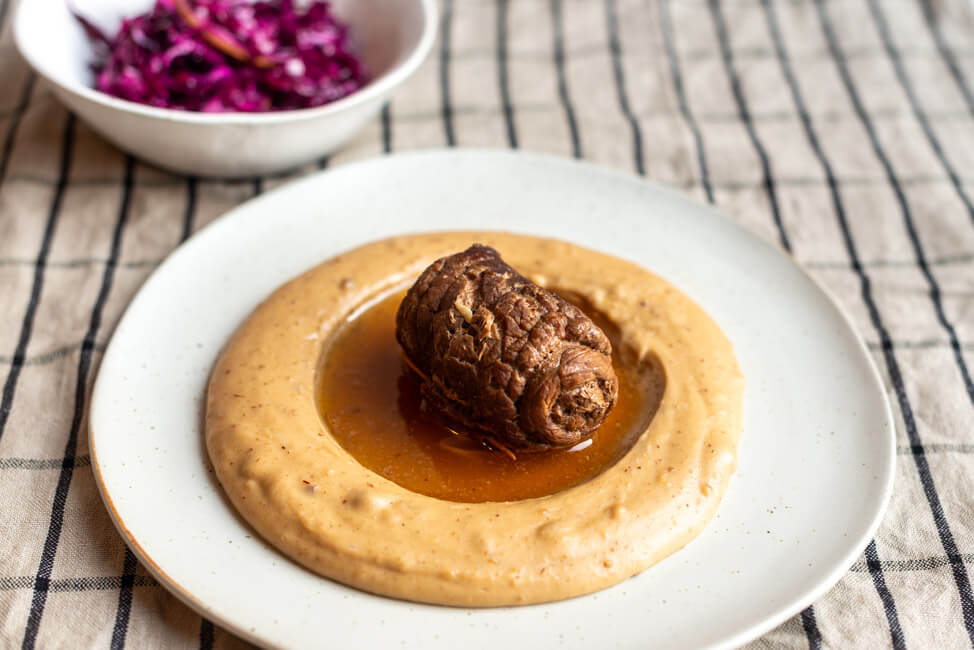 Originalrezept aus Vronis Lieblingsschmankerl: Roulade mit Maronenpüree und Rotkohlsalat auf hellem Porzellanteller von Foodbloggerin Tina.