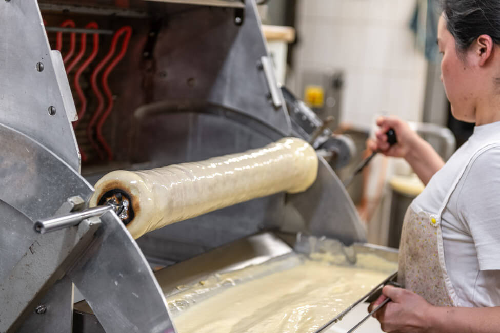 Bäckerin bereitet Baumkuchen zu