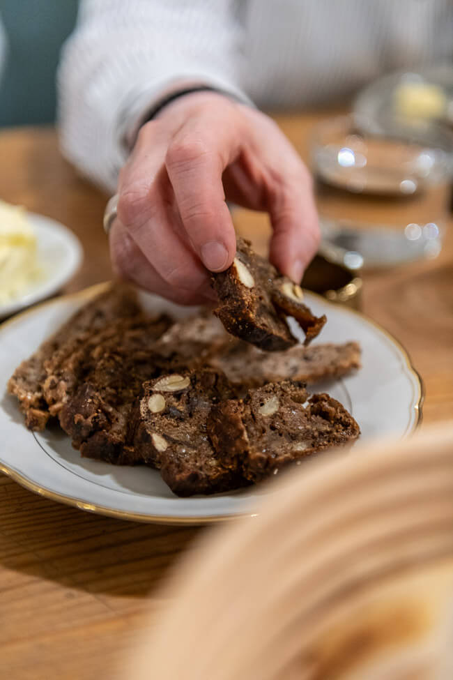 Hände greifen nach Früchtebrot von Arnd Erbel