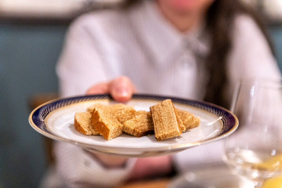 Hände halten einen Goldrandteller mit frisch gebackenen Baumkuchen von Arnd Erbel