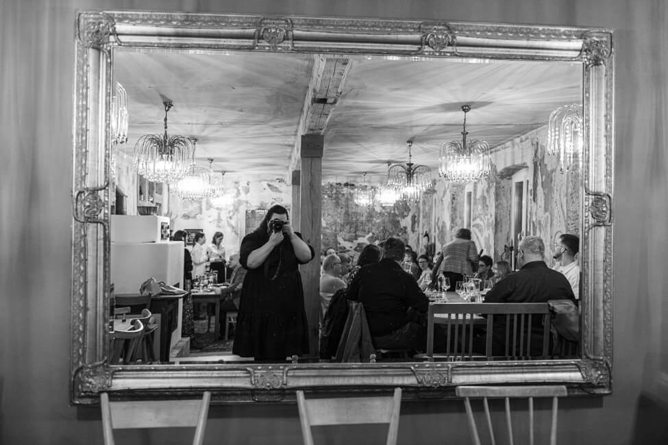 Tina Kollmann fotografiert sich selbst im Spiegel im Kaffeehaus im Aischgrund