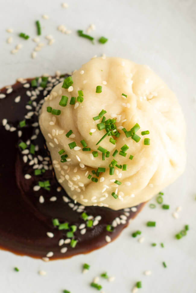 Chinesische Baozi aus Kitchen Impossible, gefüllt mit Pack Choi und Shitake Pilzen mit Dumpling Sauce auf Tonteller.