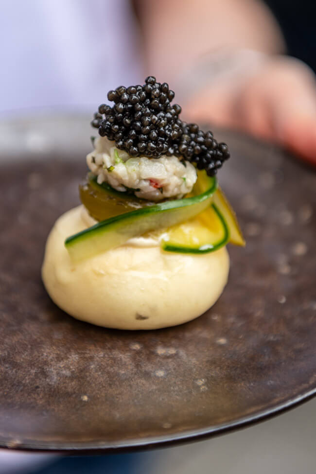 Dampfnudel gefüllt mit Stör, Umami-Gurke, Emmer-Miso und Caviar-Topping aus dem Restaurant AURA** by Alexander Herrmann und Tobias Bätz