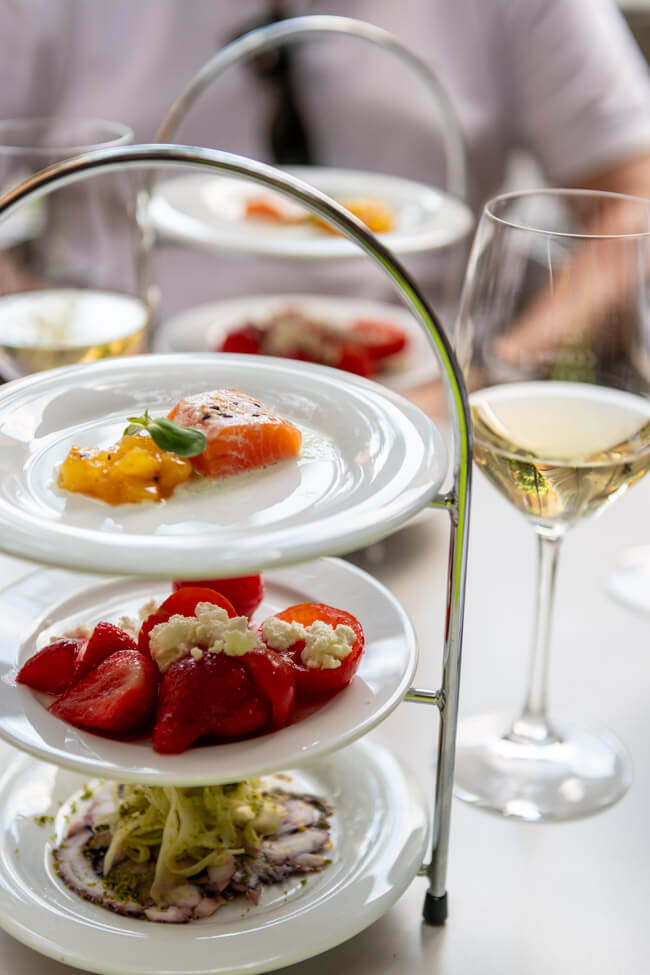 Bachsaibling mit Ananas und Gurke, Tomaten und Erbeeren mit Schafkäse und Oktopuscarpaccio mit Fenchelsalat auf Etagere