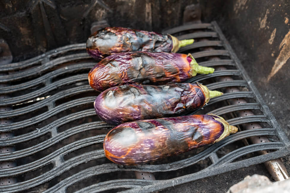 Auberginen werden auf offener Flamme gegrillt