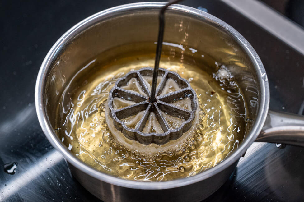 Rosettenwaffeln werden in heißem Öl frittiert