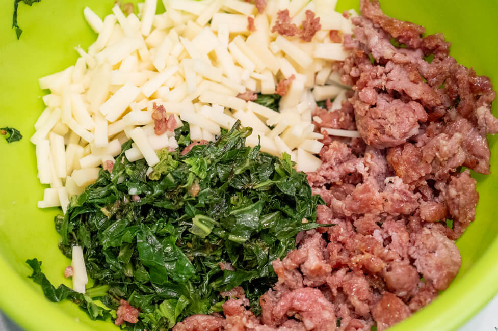 Gebratene Salsiccia, gewürfelter Provolone und gebratener Friarelli in grüner Schüssel