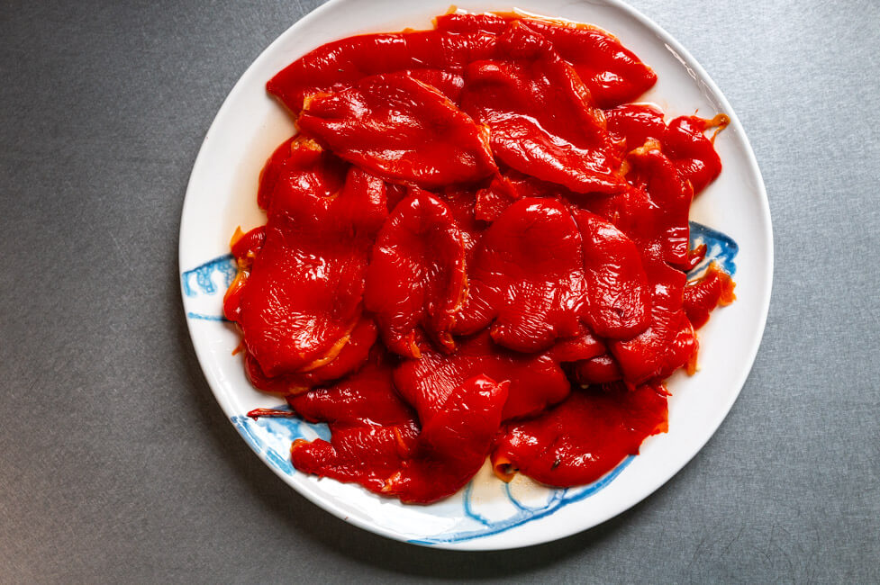 Paprika gehäutet auf hellem Teller und Edelstahl Untergrund