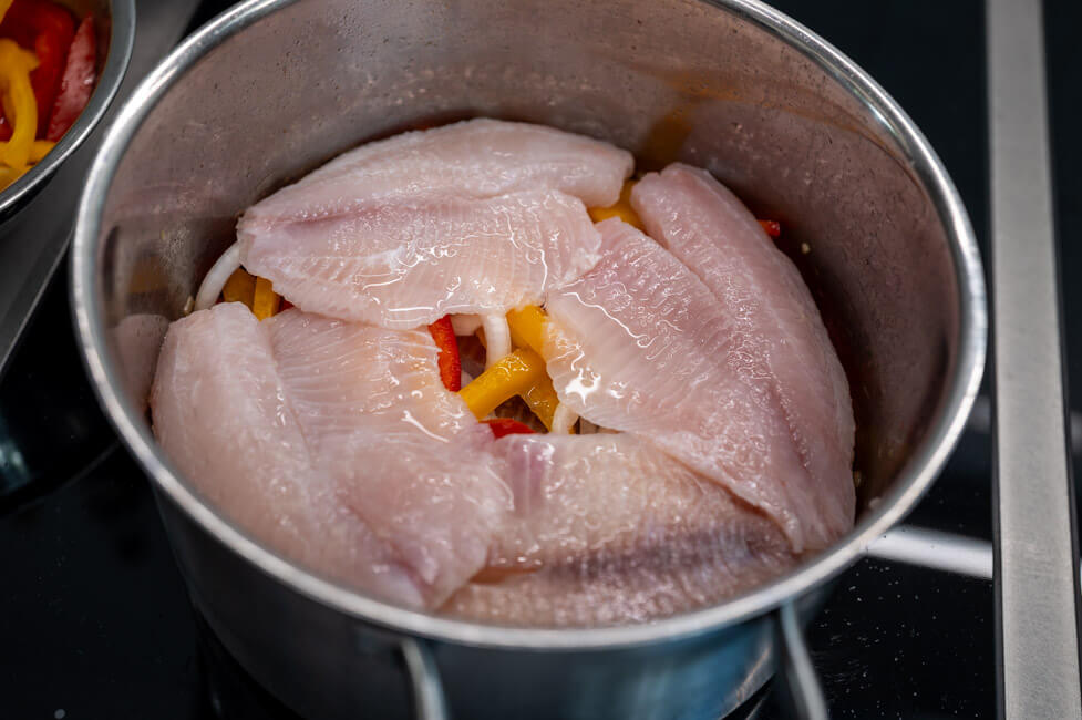 Fisch und Gemüse im Topf schichten