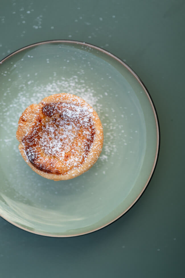 Pasteis de Nata auf grünem Teller und grünem Untergrund