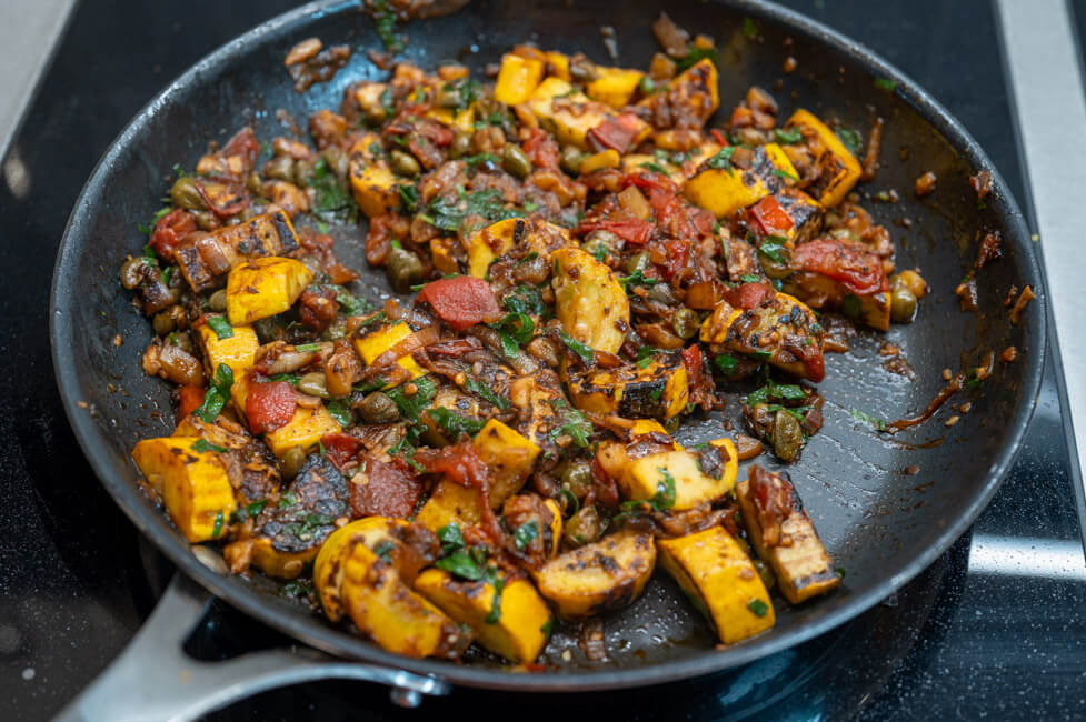Caponata mit Zucchini in einer Pfanne