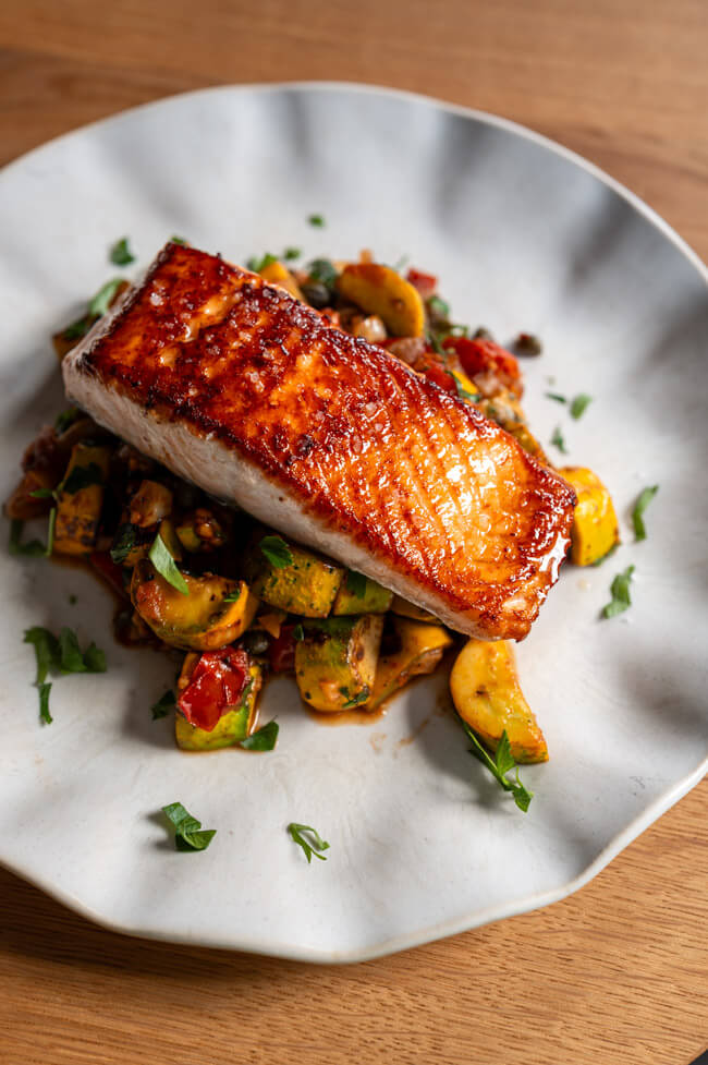 Gebratenes Lachsfilet mit grobem Salz auf Caponata