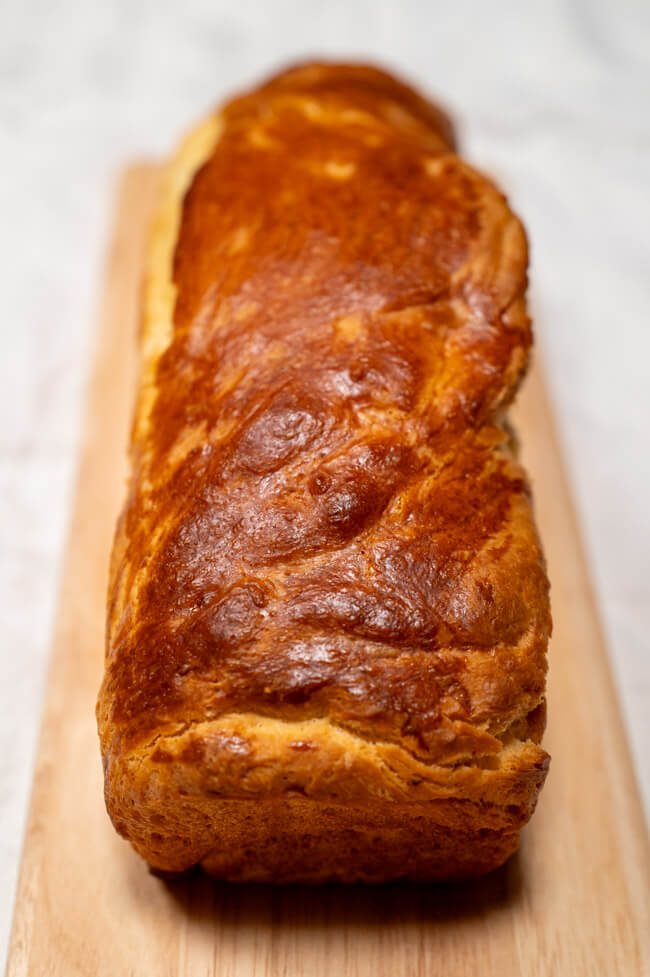 Brioche auf Holzbrett und weißem Untergrund