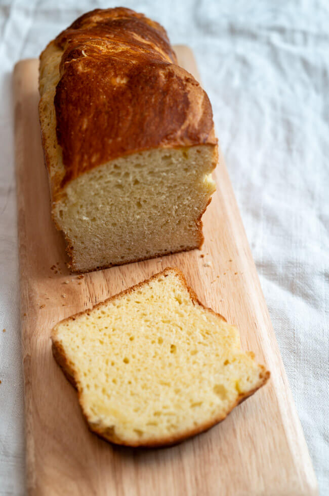 Brioche auf Holzbrett und weißem Untergrund