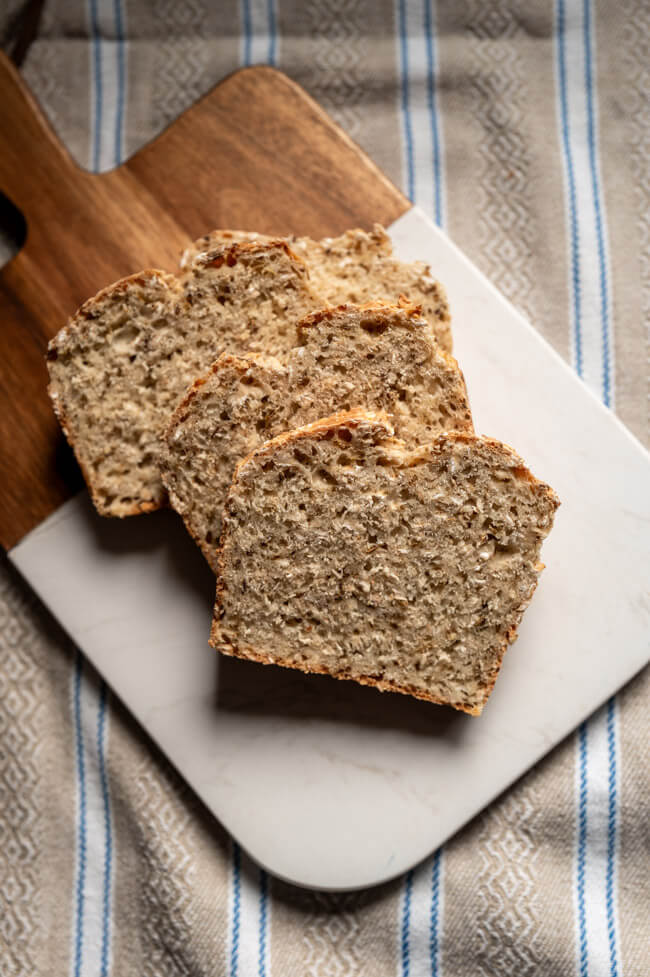 Isländisches Kümmelbrot aufgeschnitten auf Backpapier und gemustertem Tuch