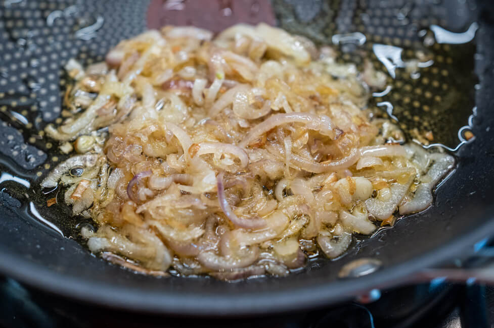 Schalotten mit Olivenöl in einer Pfanne dünsten