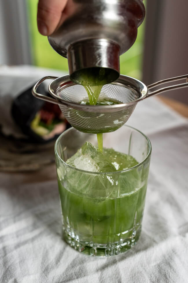 Gin Basil Smash wird in Tumbler gegossen
