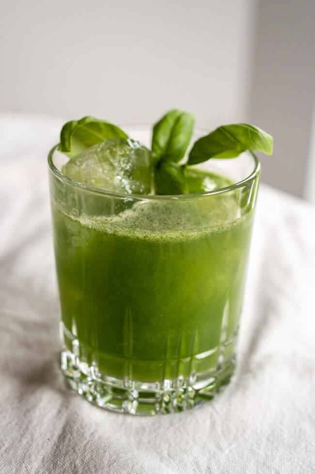 Gin Basil Smash angerichtet in Tumbler mit Eis und Baislikumblatt