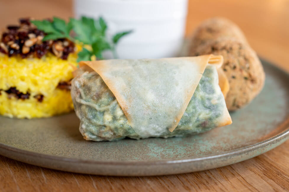 Börek mit gemischten Mezze auf grünem Teller